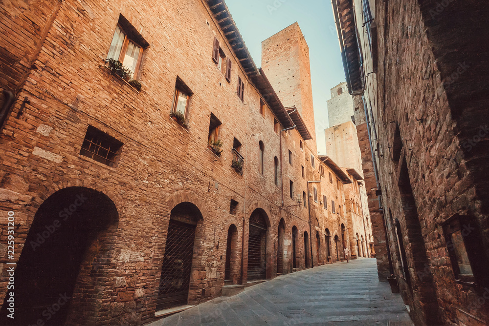 Narrow streets between brick houses of the ancient town of Tuscany. Historic Centre of San Gimignano. UNESCO World Heritage Site.
