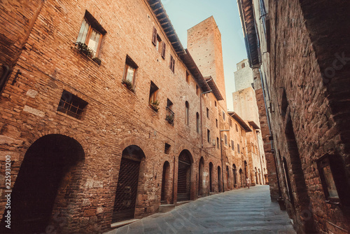 Narrow streets between brick houses of the ancient town of Tuscany. Historic Centre of San Gimignano. UNESCO World Heritage Site.