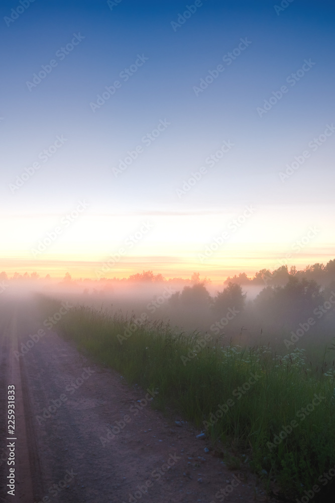 Beautiful morning sunrise landscape. Scenic Countryside landscape under a colorful sky at sunset dawn sunrise. Sunrise sky and the morning mist on the village road