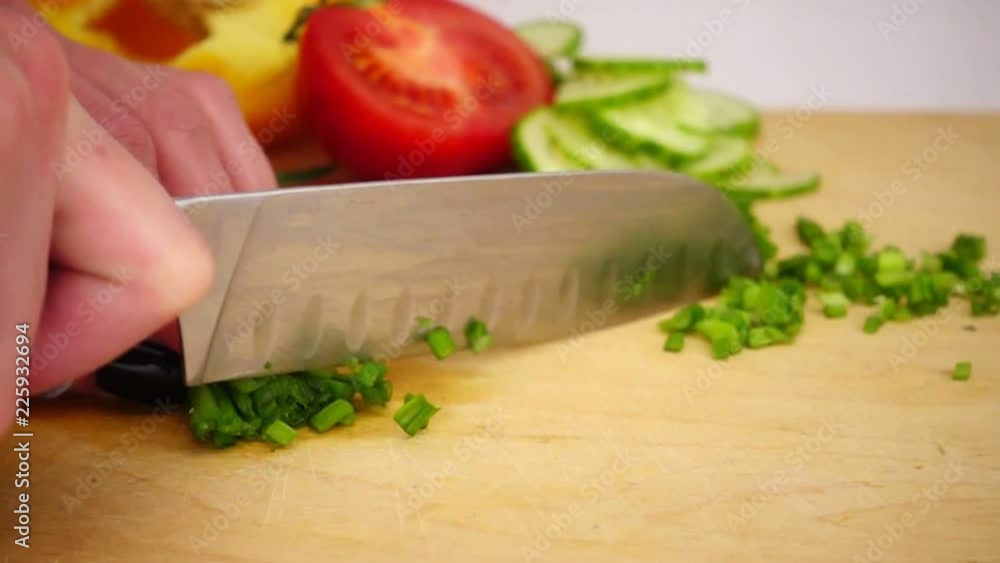 Slice green onions with a knife on a wooden board, Slow motion Slice green onions with a knife on a wooden board, Slow motion
