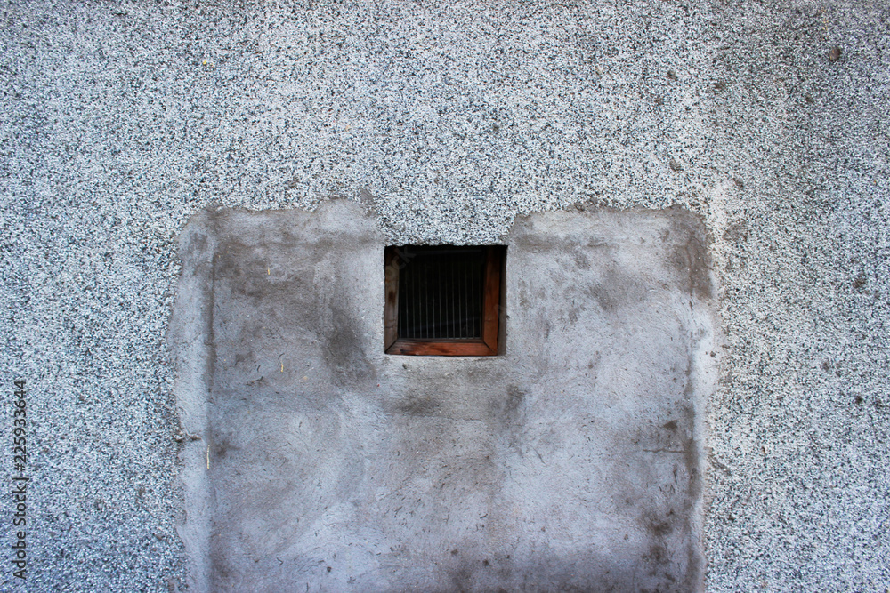 a small square window with a wooden frame leading to the basement, covered with fine grating and glass a small square window with a wooden frame leading to the basement, covered with fine grating and glass
