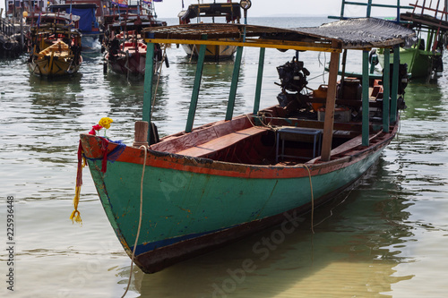 Traditional wooden boat closeup in Cambodia. Koh Rong island seaside view with coral beach and fisherman boat.
