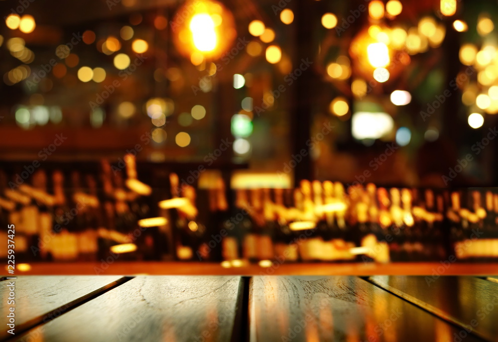 top of wood table with blur bottle of alcohol drinking for night party and  colorful light of pub and bar background Stock Photo | Adobe Stock