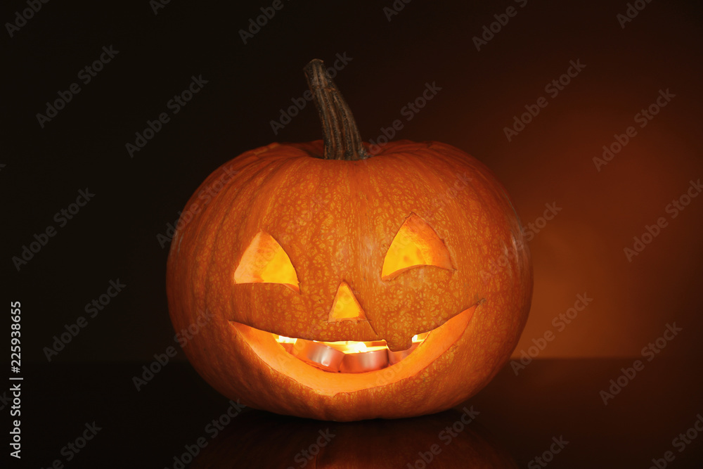 Halloween pumpkin head. Glowing jack lantern on dark background Halloween pumpkin head. Glowing jack lantern on dark background