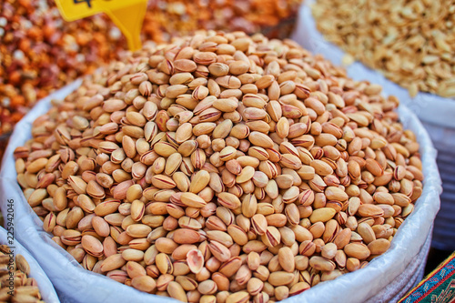 Pistachio, walnut, almond, , and nut in round metal trays in an authentic bazaar photo