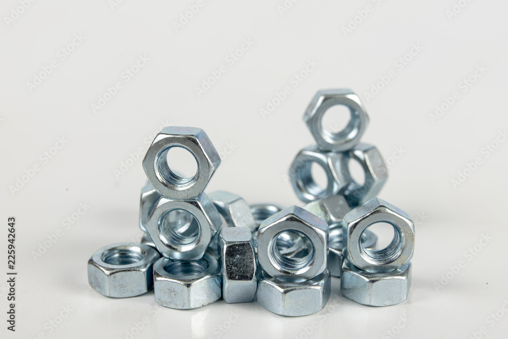 Chrome caps on a white table. Accessories for mounting steel structures on a workshop table. Chrome caps on a white table. Accessories for mounting steel structures on a workshop table.