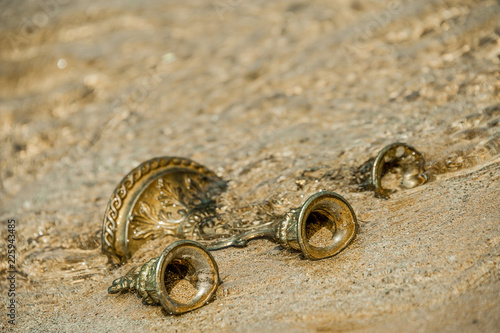 Bronze candlestick beached by the waves and discovered after a storm