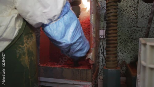 Wallpaper Mural Lab worker wearing white dress-uniform with gloves is taking orange plastic cylinder shaped water filters out of sleeve of rotating machine in industrial laboratory room. Torontodigital.ca