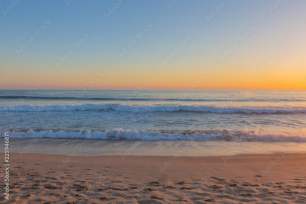 Sunset over ocean waves and beach