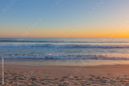 Sunset over ocean waves and beach