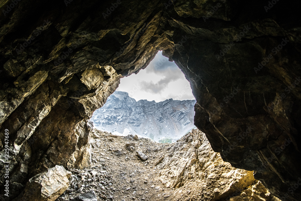 Grotta tra le montagne della Val di Fassa, paesaggio delle Dolomiti visto da una grotta tra le rocce