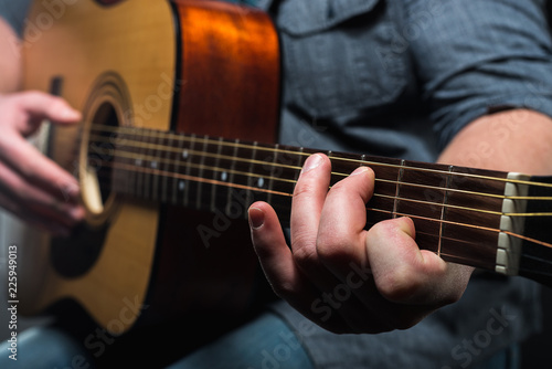 acoustic guitar in the hands of the guy on the whole frame