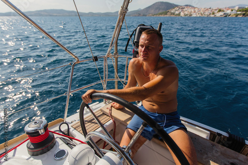 Man skipper runs a sailing yacht on the Sea. © De Visu