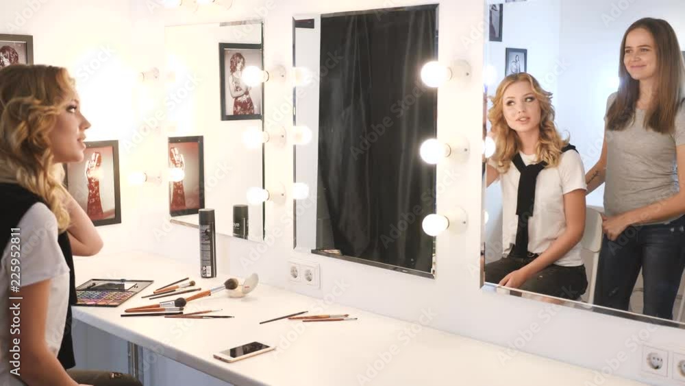 Portrait of pretty, young woman with makeup artist. Smiling Portrait of pretty, young woman with makeup artist. Smiling