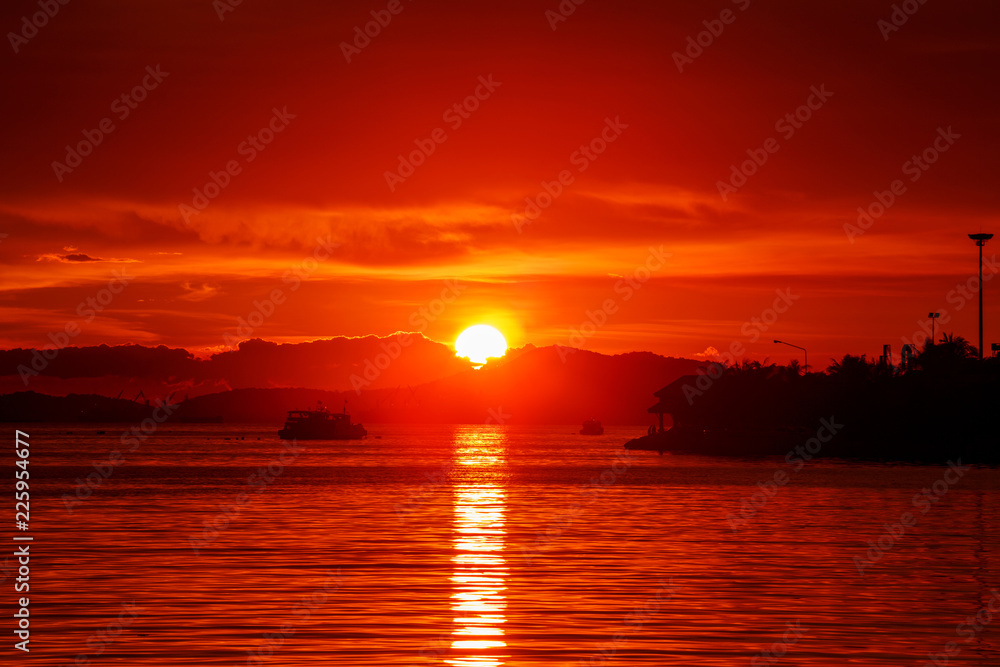 Sun setting in between silhouette mountain range and islands, Thailand famous place called Koh-Loy at Chonburi, shot taken by using long exposure technic therefore smooth water surface like mirror Sun setting in between silhouette mountain range and islands, Thailand famous place called Koh-Loy at Chonburi, shot taken by using long exposure technic therefore smooth water surface like mirror
