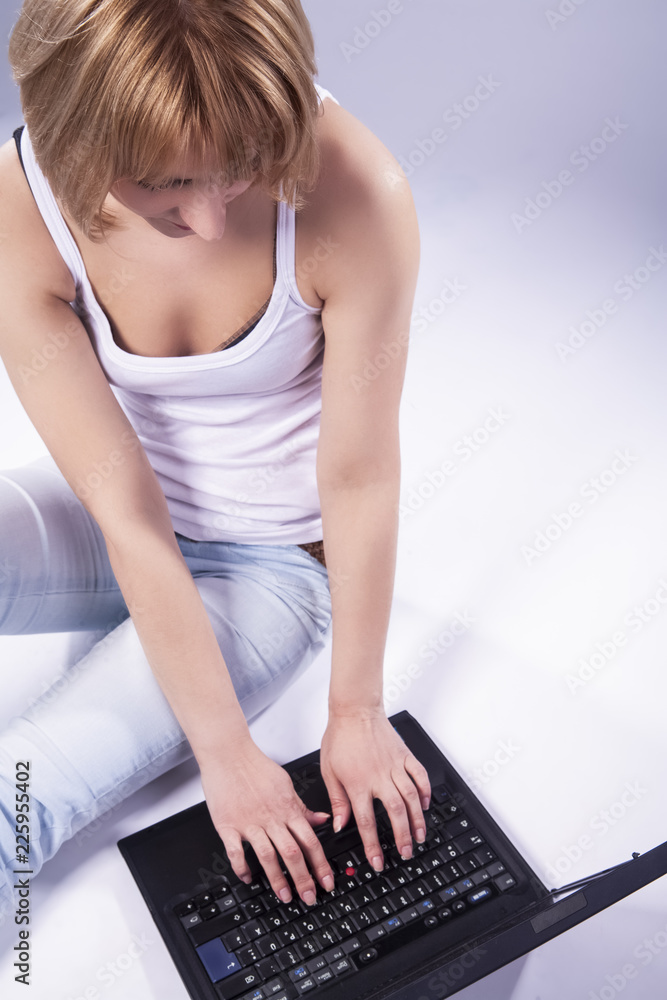 Naklejka premium Youth Lifestyle Ideas and Concepts. Tranqiul Caucasian Blond Woman Posing With Laptop Against White Backgound. Sitting on Floor.
