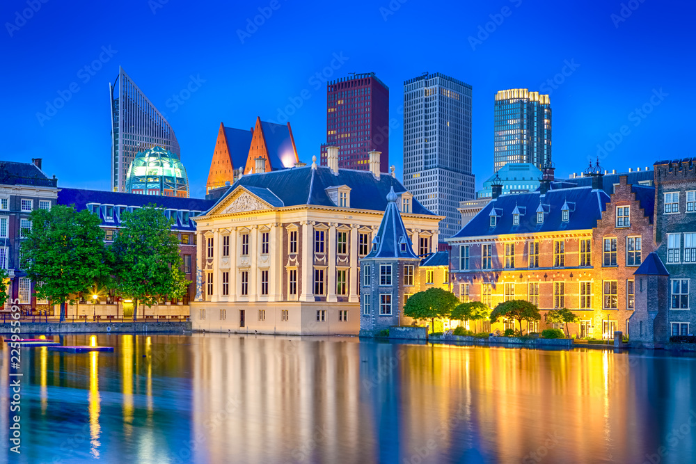 Fototapeta premium Travel Ideas. Binnenhof Palace of Parliament in The Hague in The Netherlands at Blue Hour. Against Modern Skyscrapers.