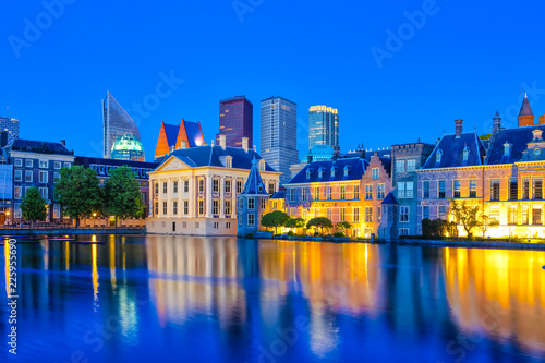 Travel Concepts. Binnenhof Palace of Parliament in The Hague in The Netherlands at Blue Hour. Against Modern Skyscrapers