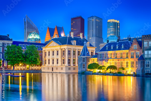 Travel Ideas. Binnenhof Palace of Parliament in The Hague in The Netherlands at Blue Hour. Against Modern Skyscrapers. photo