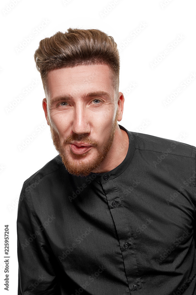 Portrait of a serious bearded man in a black shirt, isolated over a white background. Portrait of a serious bearded man in a black shirt, isolated over a white background.