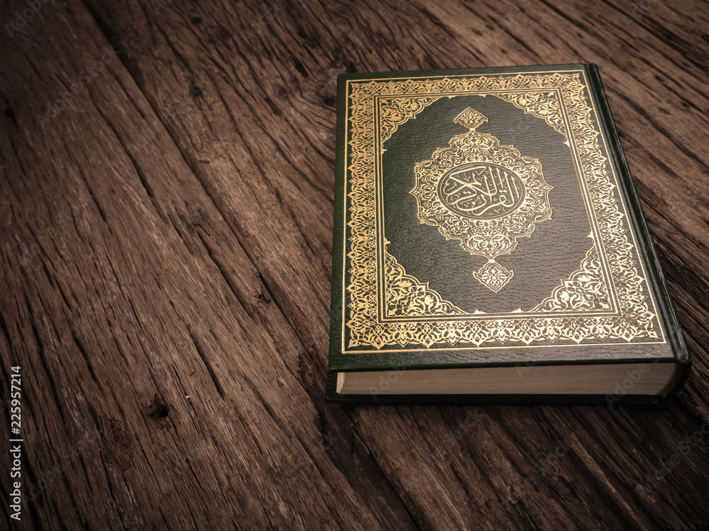Koran - holy book of Muslims ( public item of all muslims ) on the table , still life Koran - holy book of Muslims ( public item of all muslims ) on the table , still life
