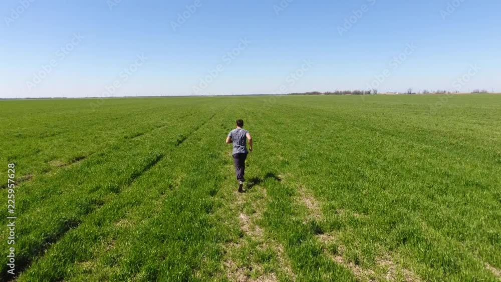 A man running through the field. Jogging in the fresh air A man running through the field. Jogging in the fresh air