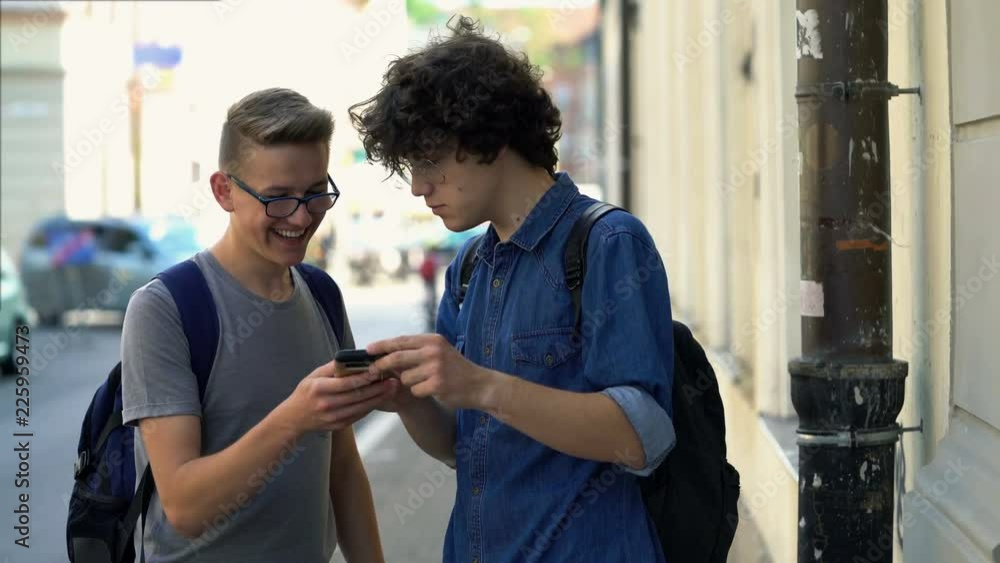 Two friends talking, laughing over smartphone, standing in the city
Two friends talking, laughing over smartphone, standing in the city
