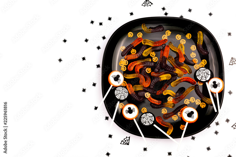 Obraz premium A plate with Halloween sweets on the white background. Children or adult party concept. Flat-lay, top view. Copy space for your text.
