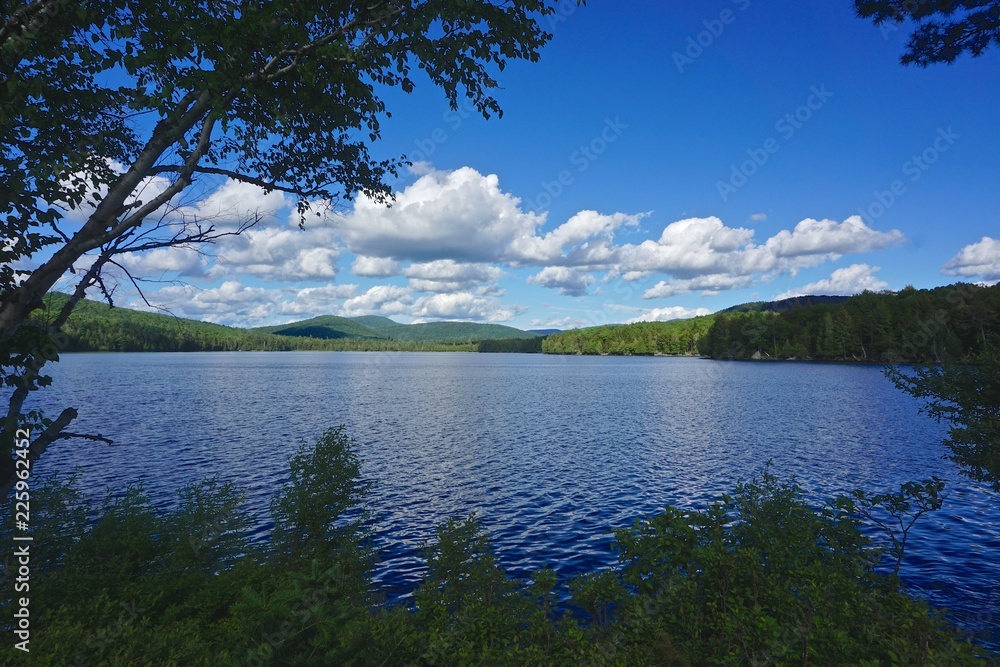 Adirondack Park, New York: Sagamore Lake, with dramatic clouds overhead, on a bright summer day.