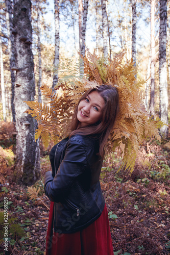 woman autumn portrait. cute girl outdoors with a bouquet of yellow fern in the forest, autumn fall concept