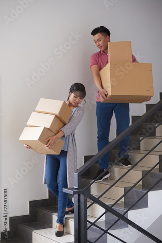 Canvas-taulu Couple bringing boxes with their belongings downstairs