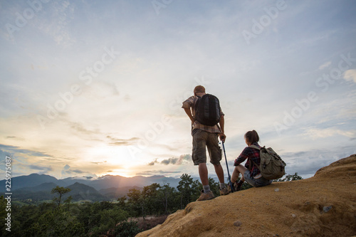 Couple Man and Woman sitting on cliff enjoying mountains, Travel happy emotions Lifestyle concept. © Tinnakorn
