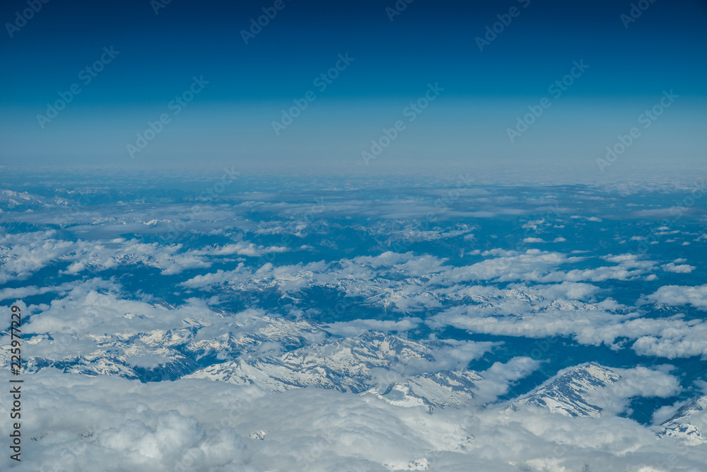 White heavy clouds in the blue sky. Panoramic cloudscape above the clouds.