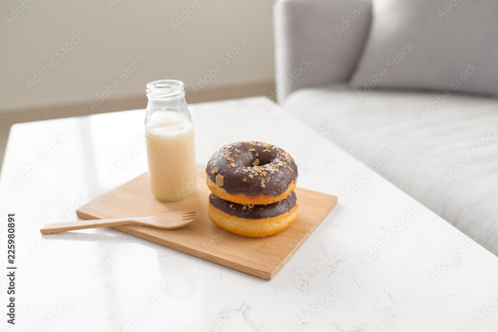 Chocolate donut. Morning breakfast with milk on table in living room at home. Chocolate donut. Morning breakfast with milk on table in living room at home.