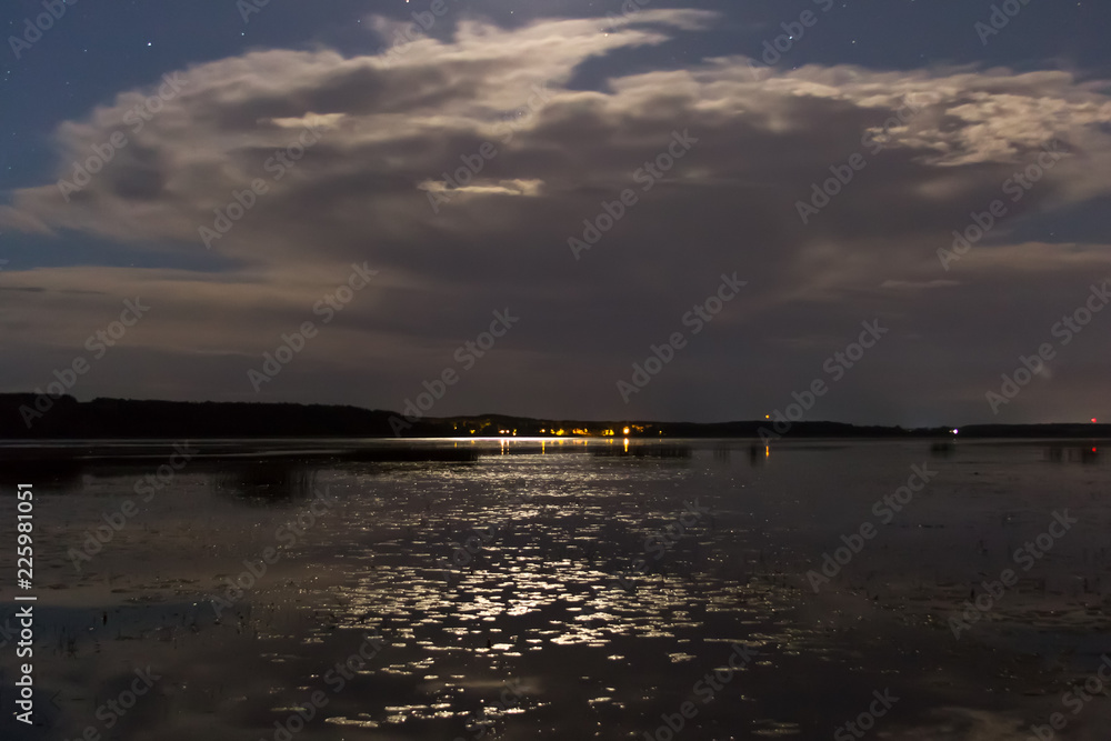 Clouds and stars above lake in the summer night before thunder Clouds and stars above lake in the summer night before thunder