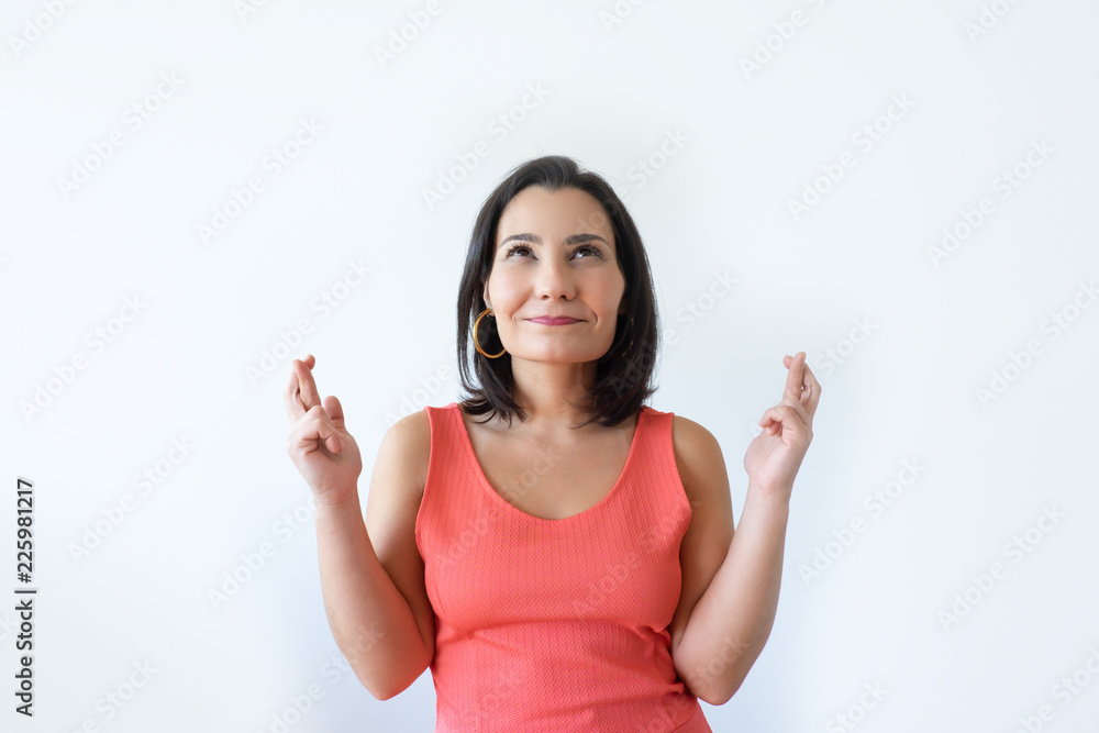 Hopeful attractive Caucasian woman crossing fingers and looking up. Pretty middle aged woman wishing for luck. Good luck concept. Hopeful attractive Caucasian woman crossing fingers and looking up. Pretty middle aged woman wishing for luck. Good luck concept.