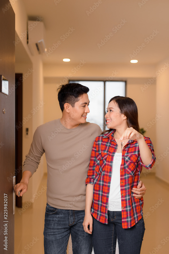 happy young couple at their new house front door proud to show home keys happy young couple at their new house front door proud to show home keys