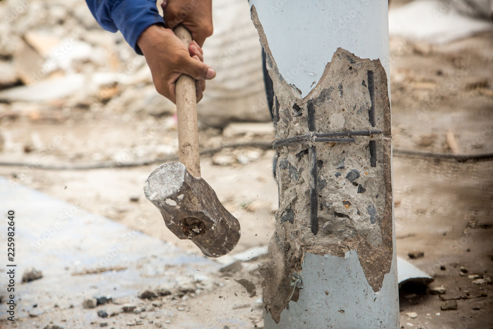 Worker holding hammer and smash to concrete pile in construction site for renovate old house. Renovation and maintenance the property is concept