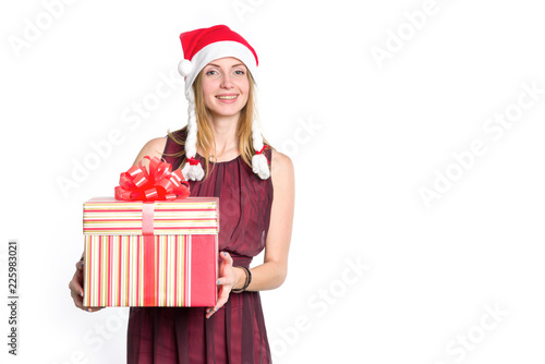 Beautiful young woman in Santa Claus hat is holding New Year's gift. Big box in hand. Christmas shopping.