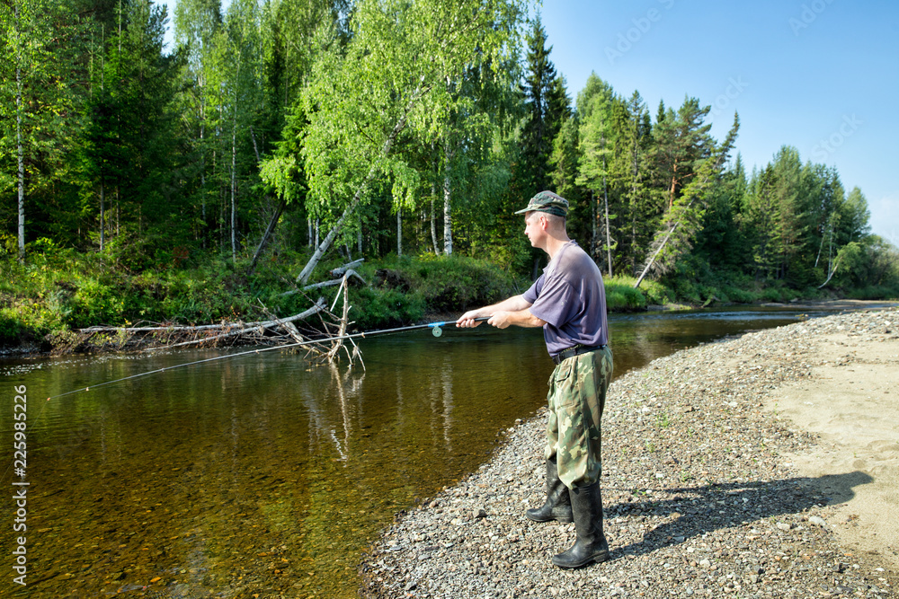 The fisherman catches fish in the river