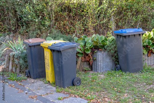 Some dustbins in front of a house