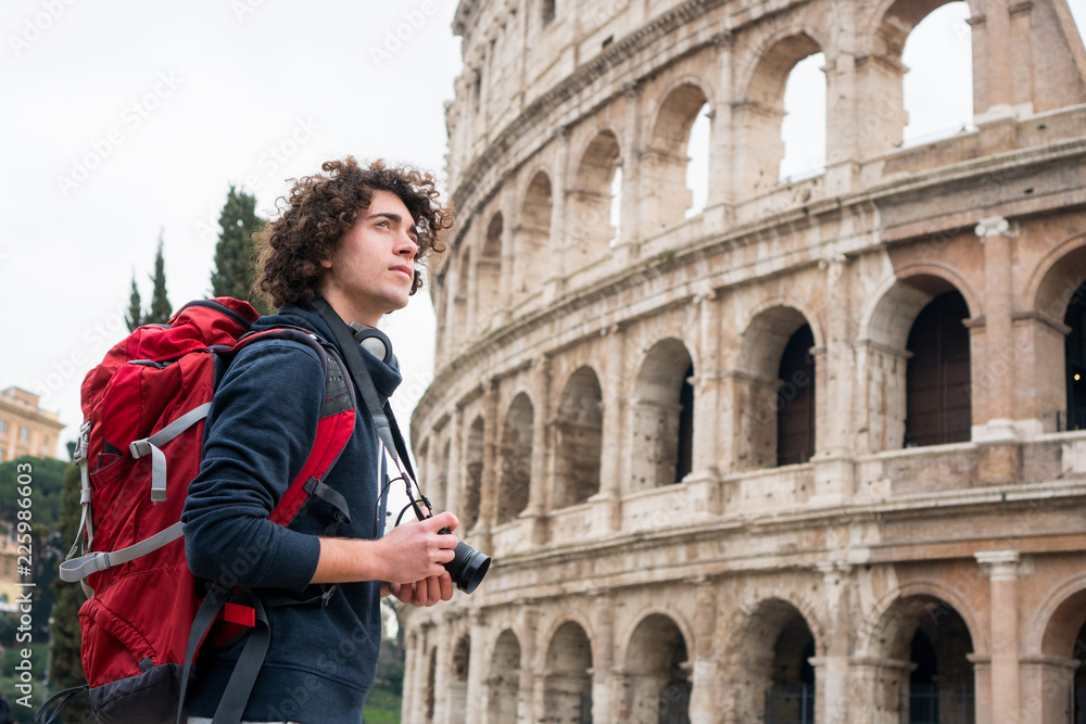 Handsome young tourist man with a camera and backpack taking pictures of  Colosseum in Rome, Italy. Young tourist taking pictures of Colosseum Stock  Photo | Adobe Stock