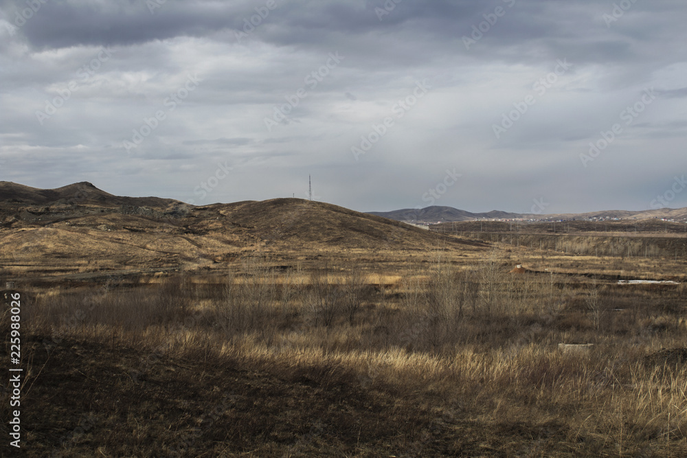 Steppe landscape. Hills and grey sky.