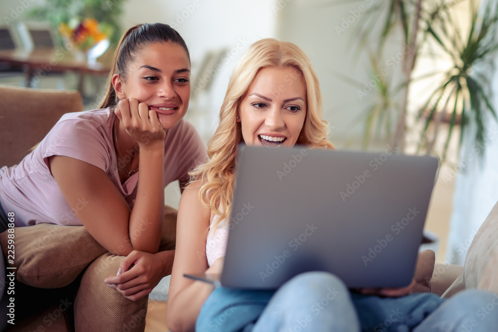Two happy female friends using laptop Two happy female friends using laptop