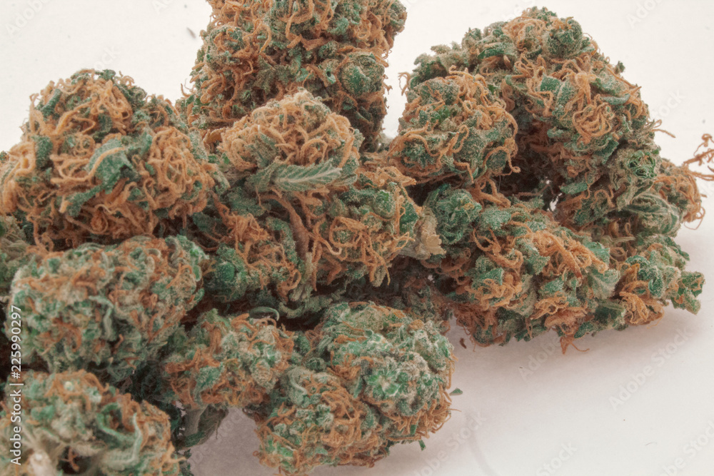 Close up of a pile of 2 different kinds of marijuana buds mixed together with a white background.