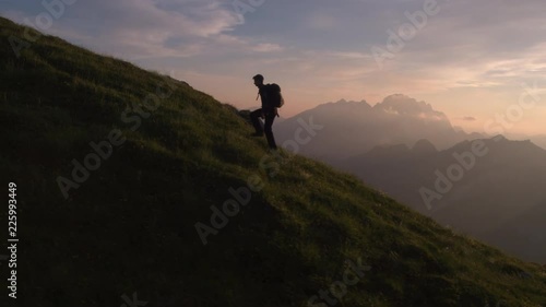 Aerial - Epic shot of a man hiking on the edge of the mountain