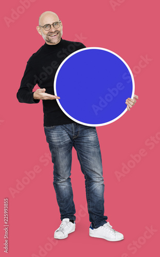Cheerful man standing holding a blue circle isolated on background