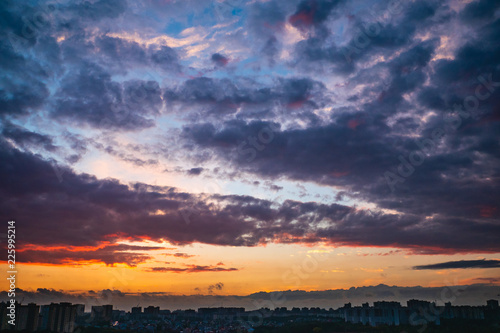 Dramatic colorful autumn clouds at sky over city at sunset, beautiful nature landscape panorama © DedMityay