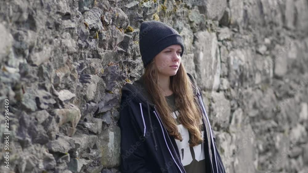 Young woman leans against the wall - lost in thoughts Young woman leans against the wall - lost in thoughts