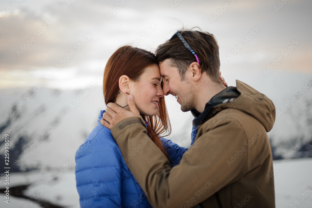 Happy couple in love on the winter vacations gently embracing in mountains Happy couple in love on the winter vacations gently embracing in mountains